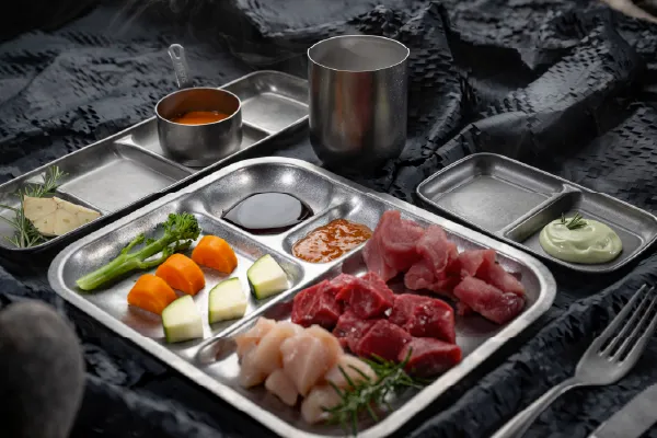 Metallene Menüschalen mit Fächern der Serie Yoko, angerichtet mit Gemüse und Fleisch